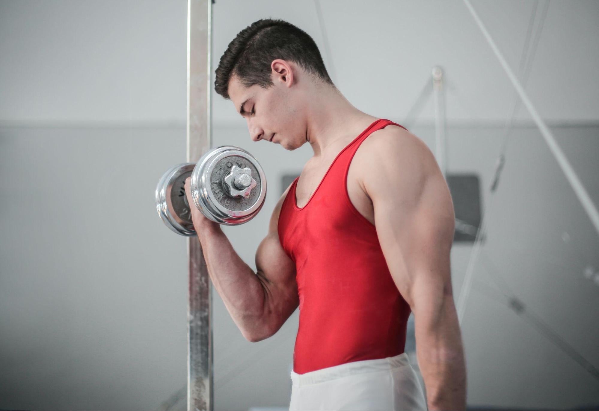  muscular man building muscle with dumbbell