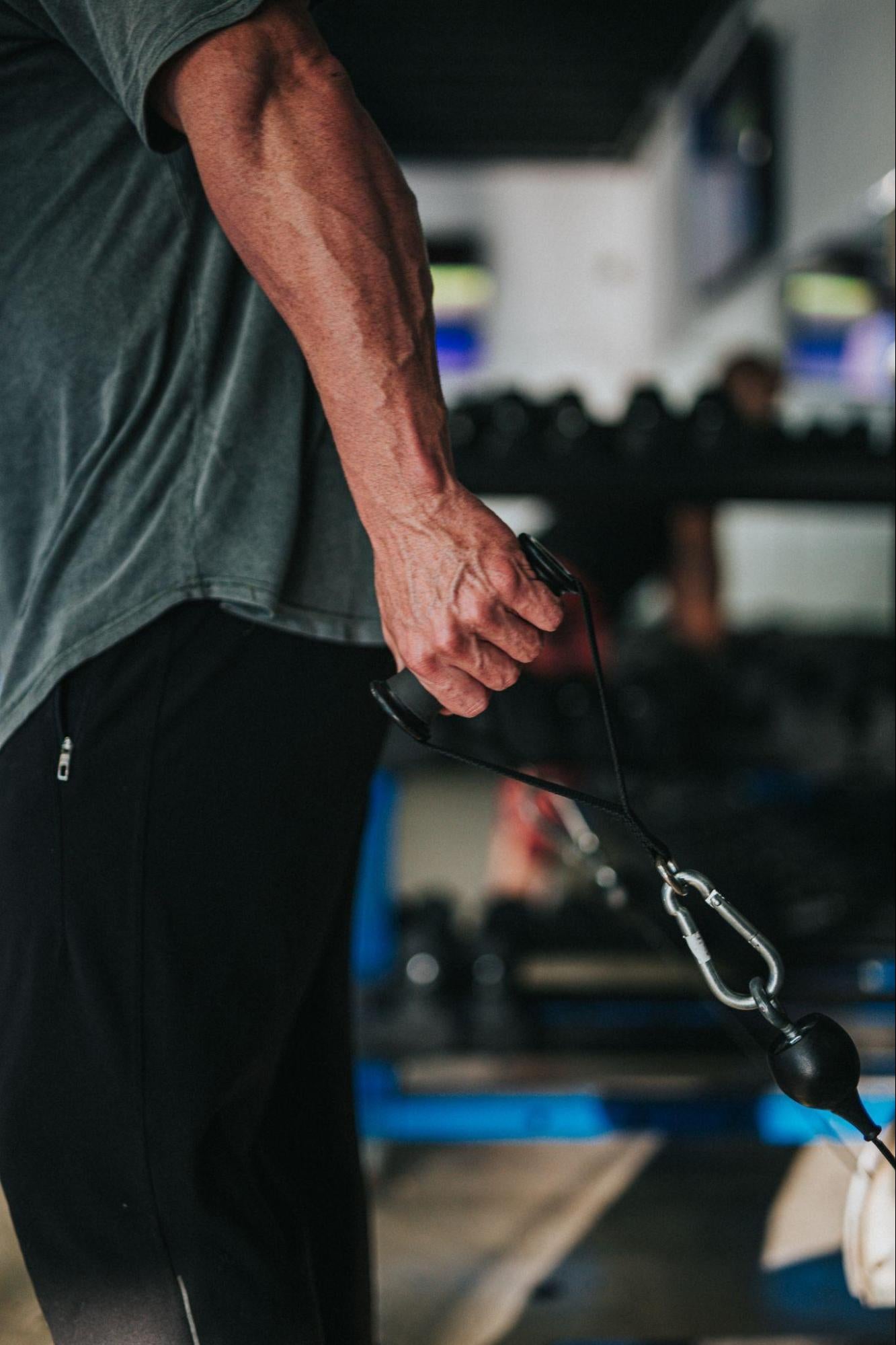  man using cable machine with flexed forearm