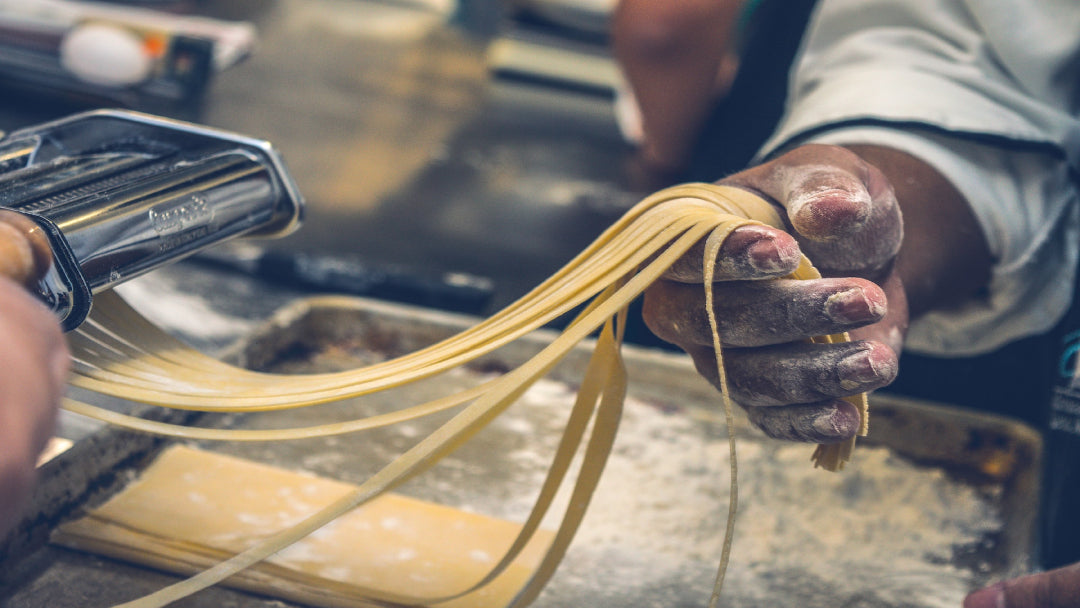 person rolling pasta